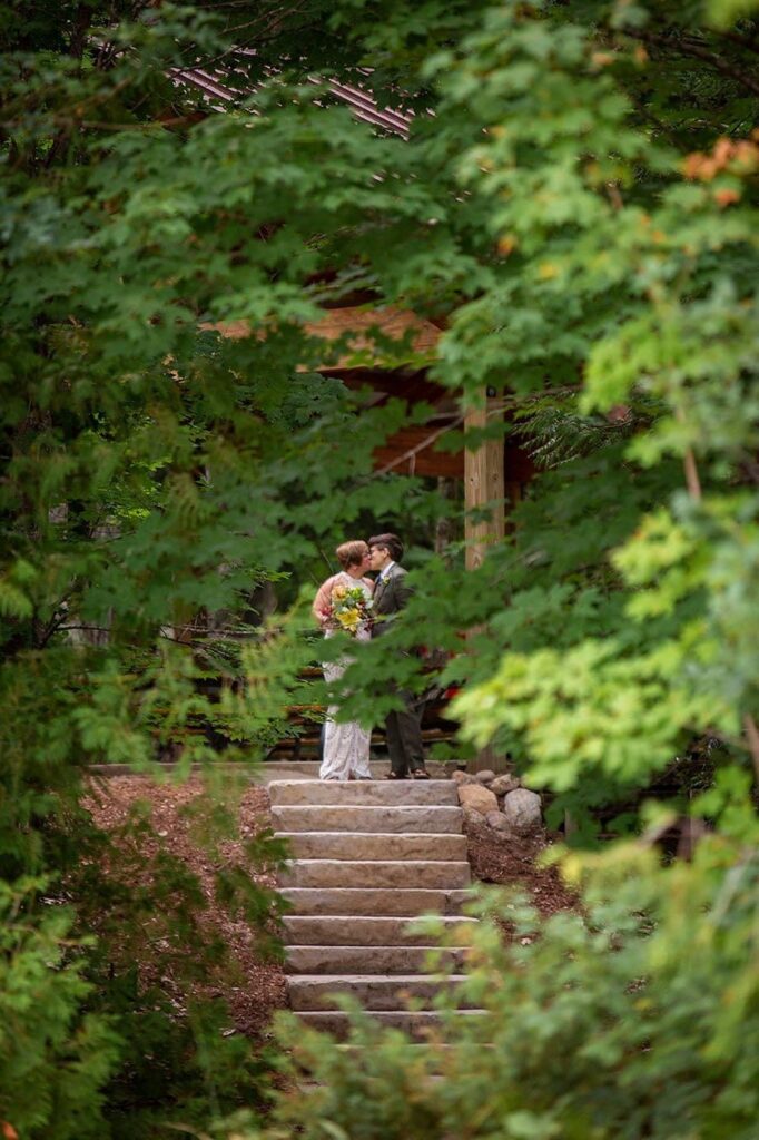 Michigan LGBTQ wedding couple shares a quick kiss before they walk down the aisle.