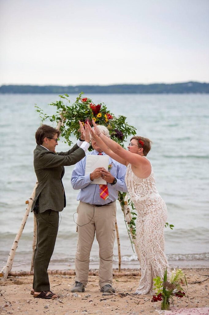 Michigan LGBTQ couple high-five as they meet each other at the altar.