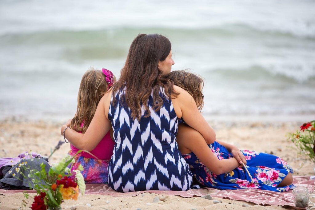 Wedding guests snuggle up on the beach at an Elk Rapids wedding