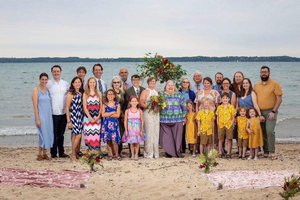 Wedding guests pose for a picture on the shores of Grand Traverse Bay.