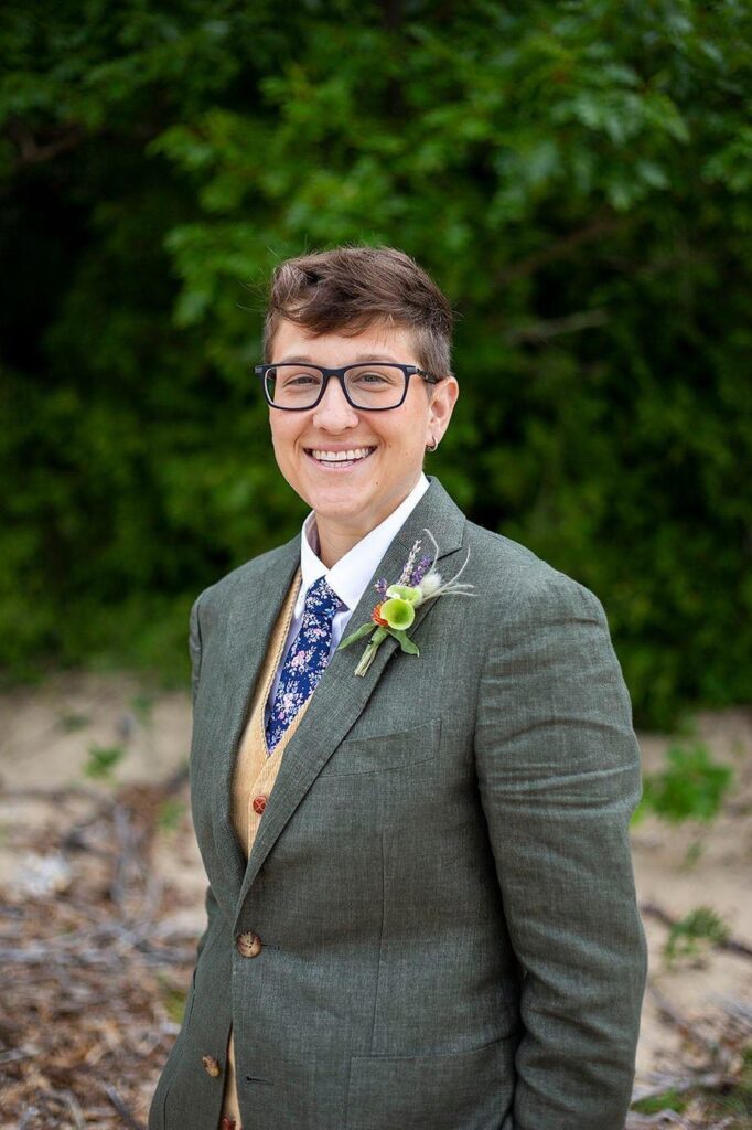 Woman in suit poses for their Michigan wedding photos.