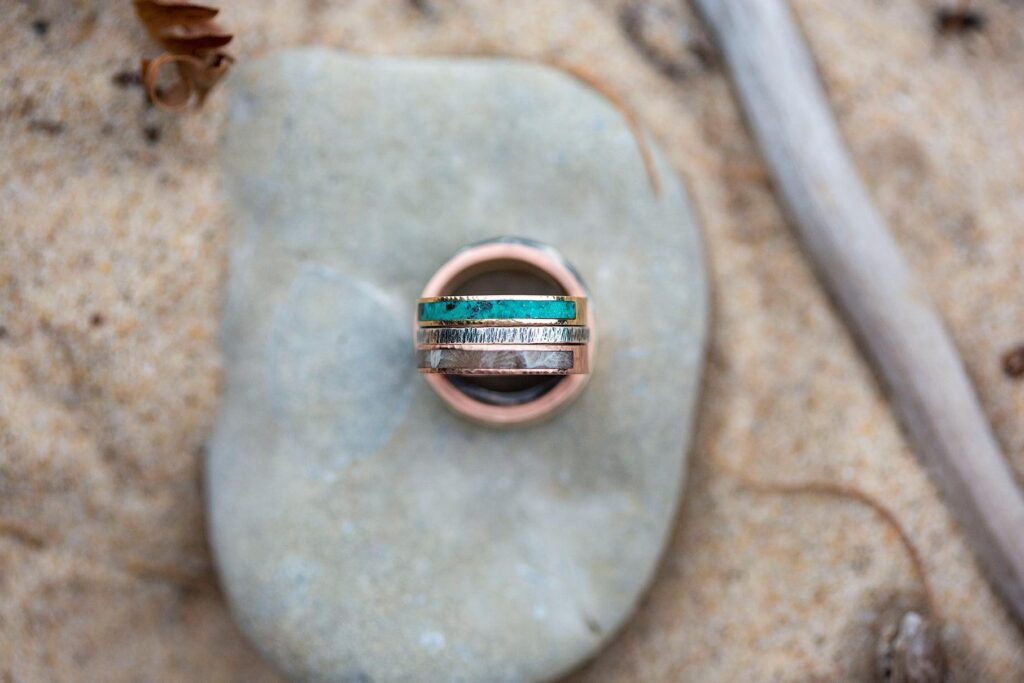 Michigan LGBTQ wedding rings perched on a rock in the sands of Grand Traverse Bay.