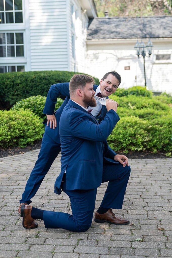 Best man cheers on the groom after icing him at his Wellers Carriage House wedding