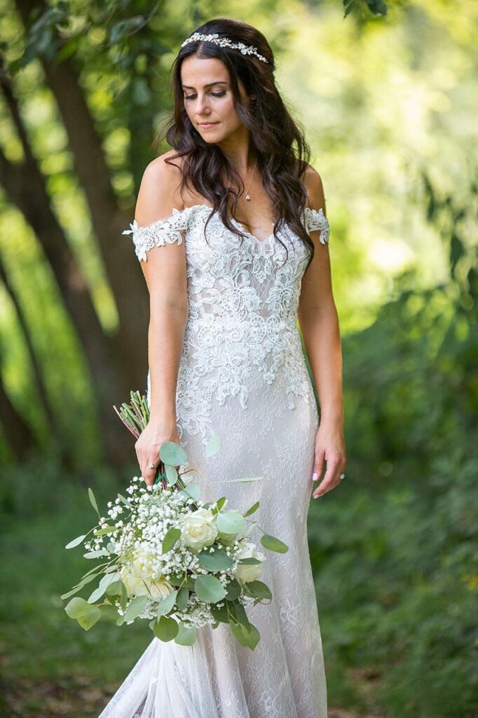 Washtenaw county wedding photographer take photo of bride looking at her bouquet.