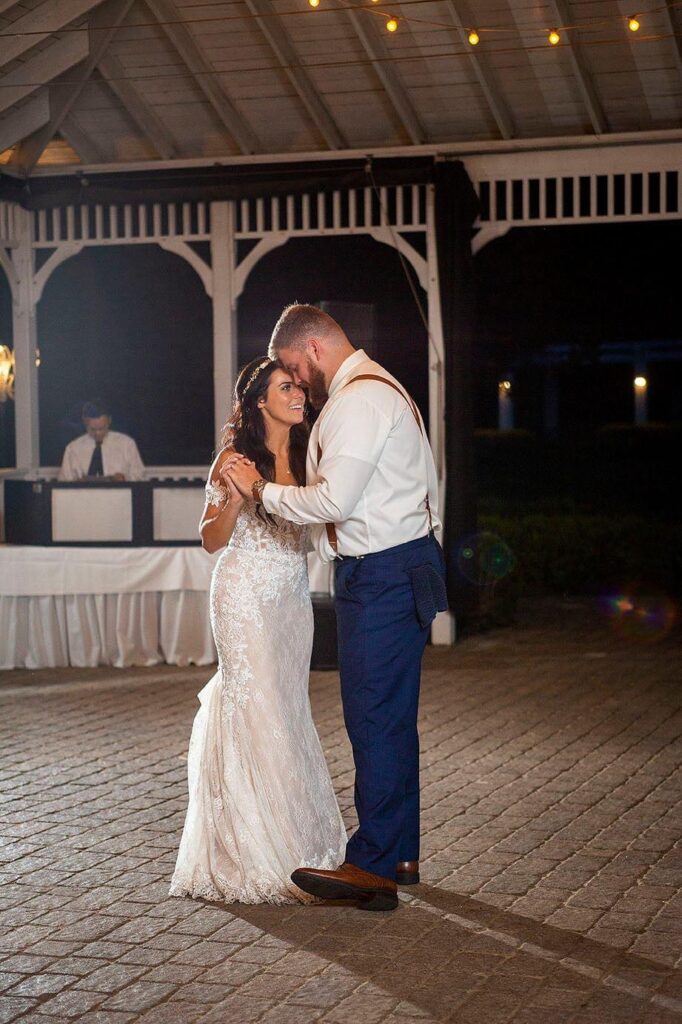 Wellers wedding couple dances at night on the outdoor dance floor.