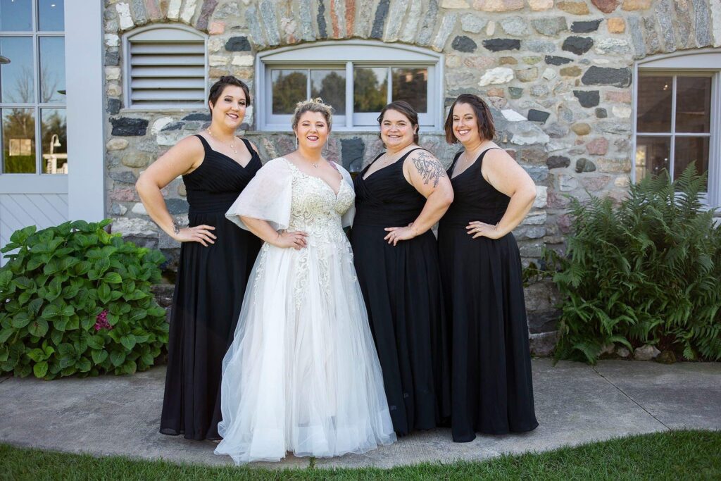 Bride and bridesmaids pose together for a photo outside of Castle Farms.