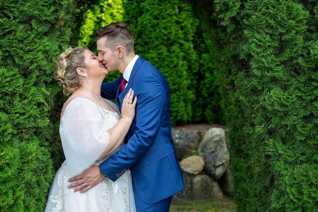 Castle Farms wedding couple kiss amongst the English garden.