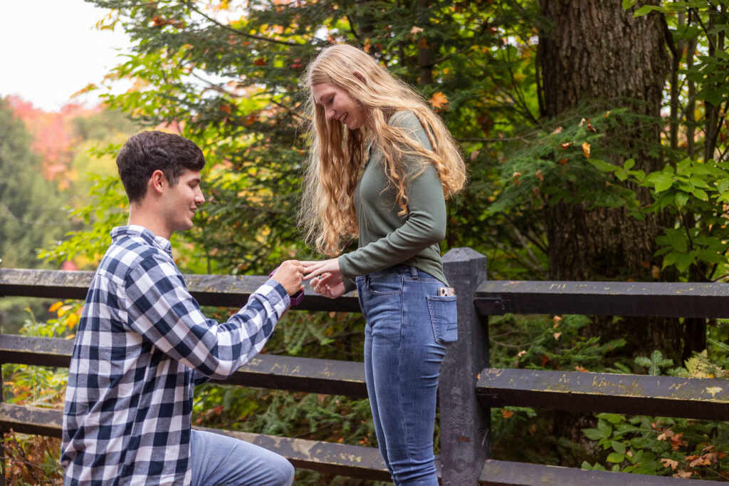 Kassidy holding Lucas's hand as he's proposing at Tahquamenon Falls in Michigan's Upper Peninsula.