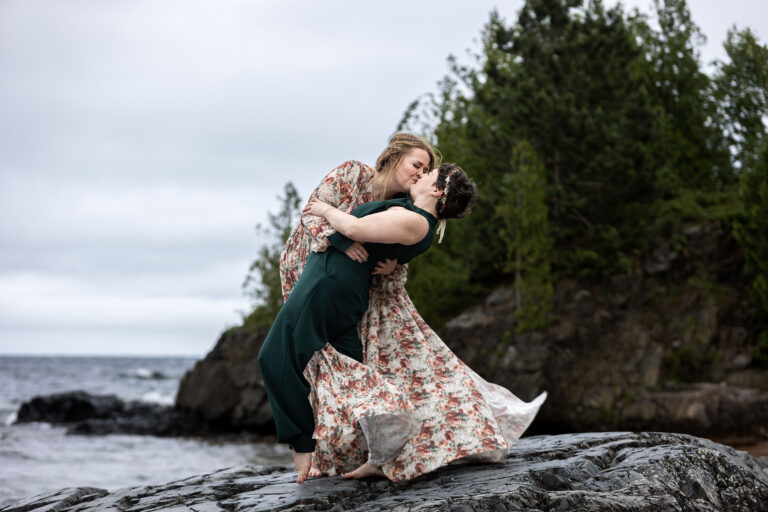 Marquette wedding LGBT couple kisses on top of the Black Rocks.