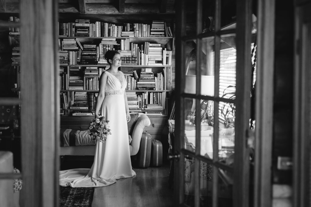 Black and white photo of bride in the library at Pinecrest Northwoods Upper Peninsula wedding photographer