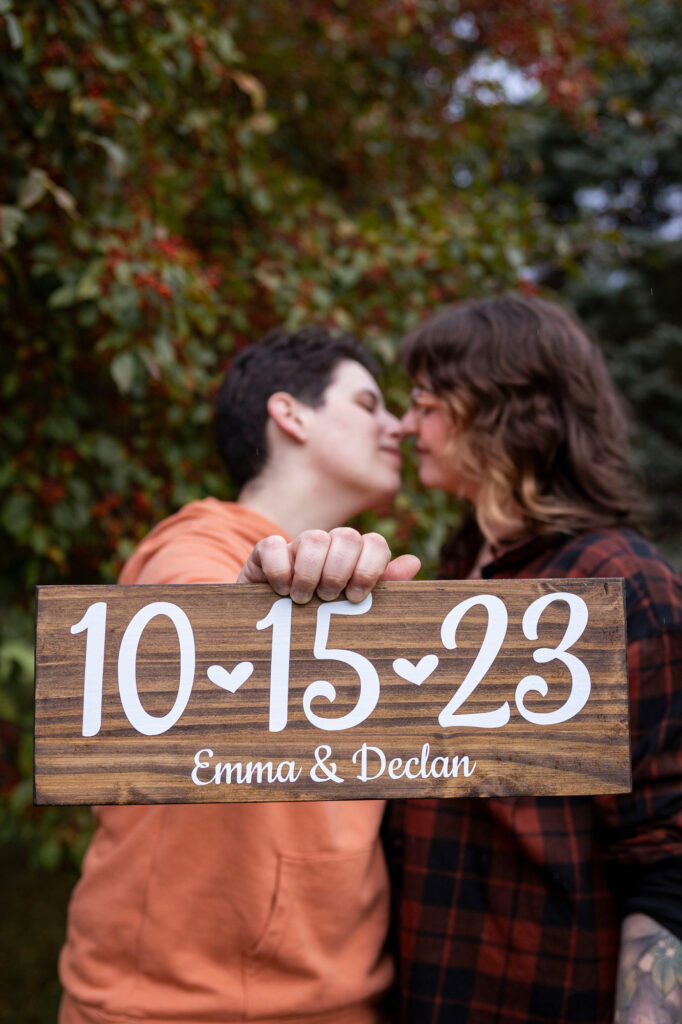 Dexter proposal LGBTQ couple hold up sign signifying the date of their engagement