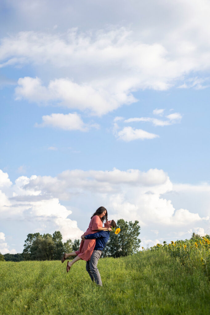 Zach twirls Sara during their sunflower field engagement session.