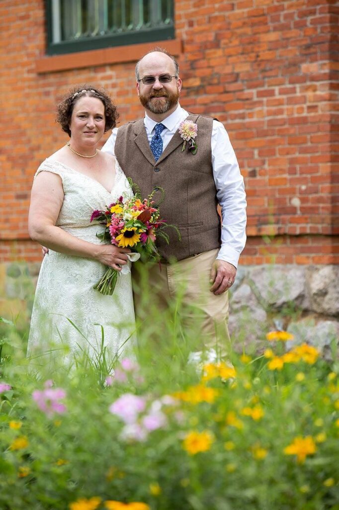 Couple in front of the bring and gardens at the Turner Dodge house.