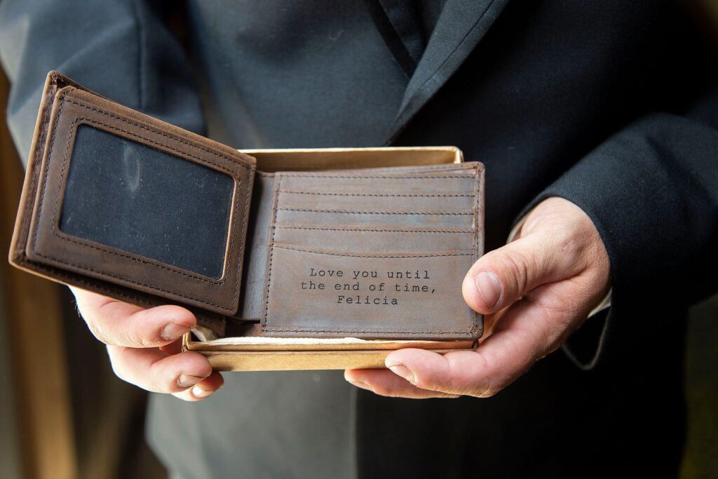 Groom holds custom leather wallet