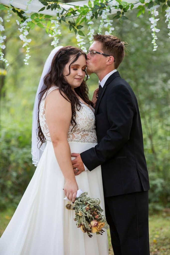 Groom kisses bride's temple at Irish Hills wedding