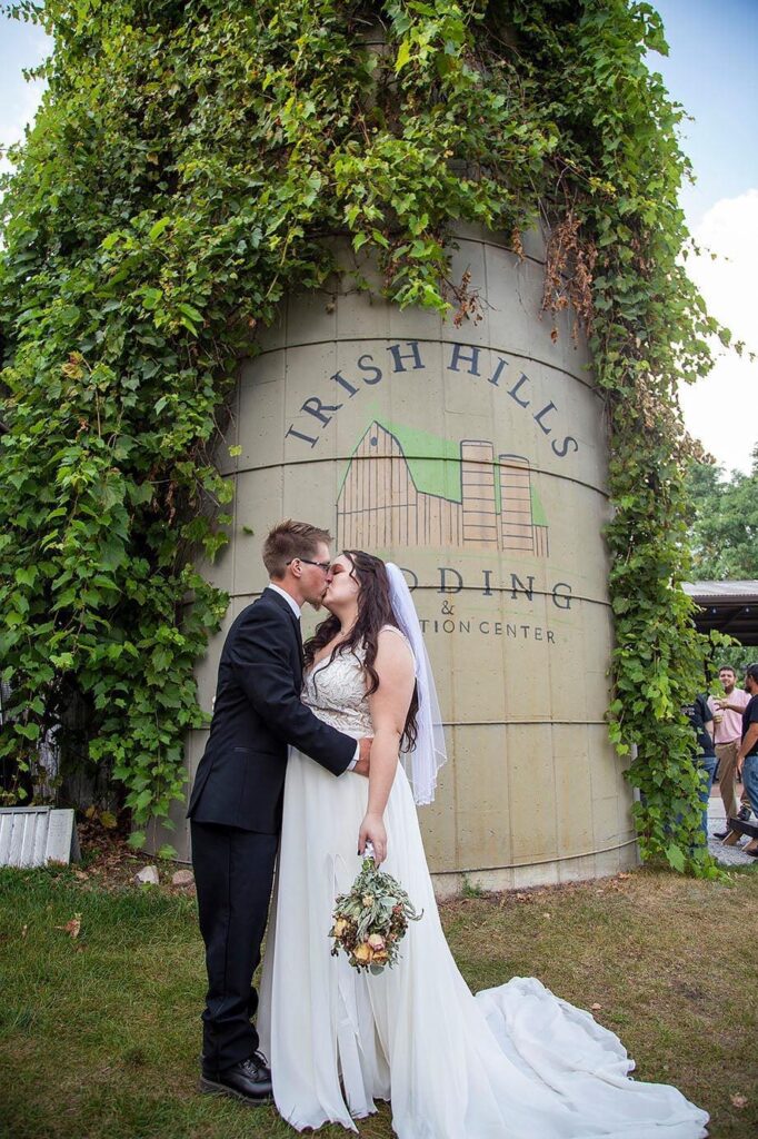 Bride and groom kissing in front of the silo at Irish Hills Barn and Convention Center