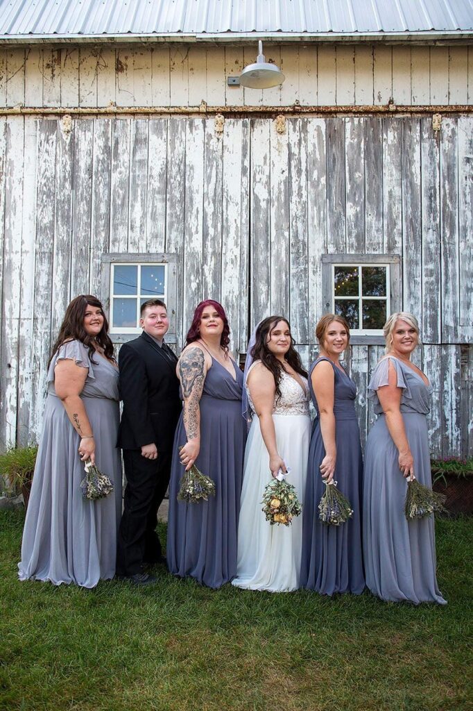 Gray wedding party in front of historic gray barn Irish Hills