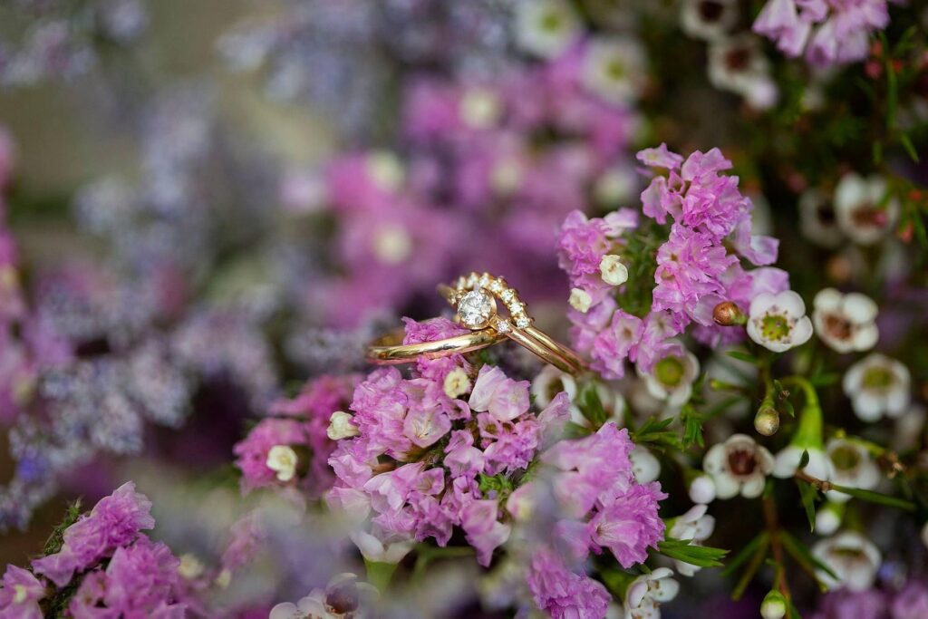 Wedding rings amongst purple bouquet west Michigan small wedding