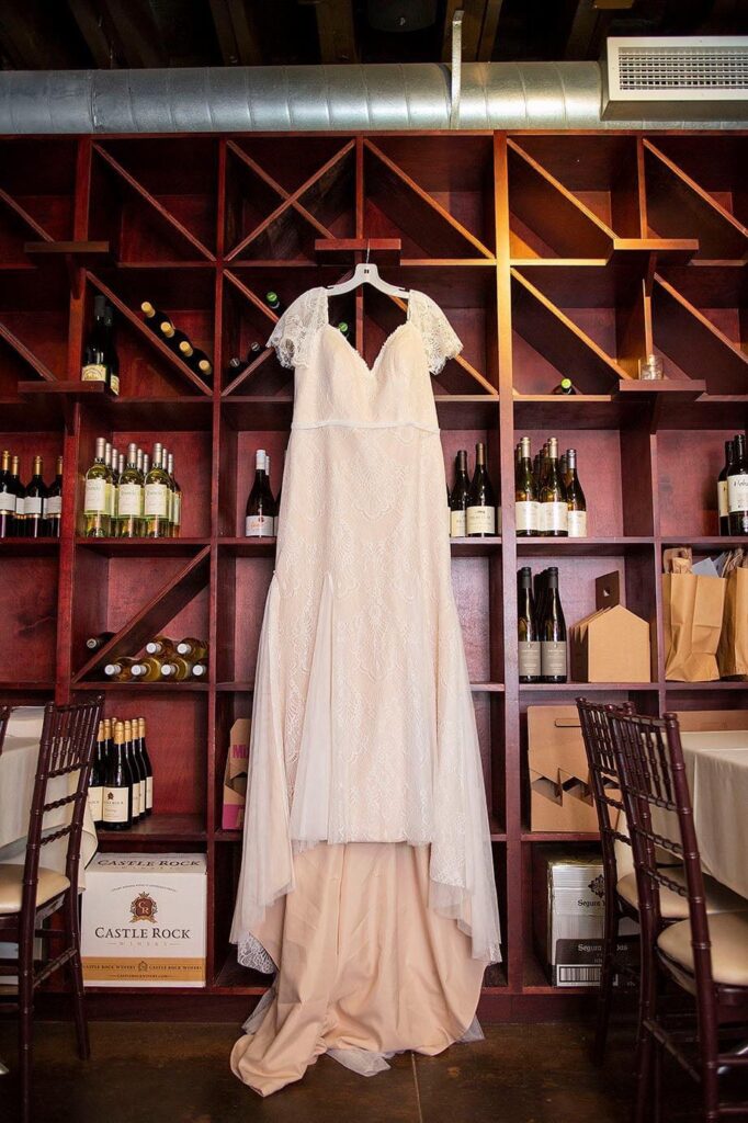 Wedding dress hanging from the wine bottles at Vinology wedding