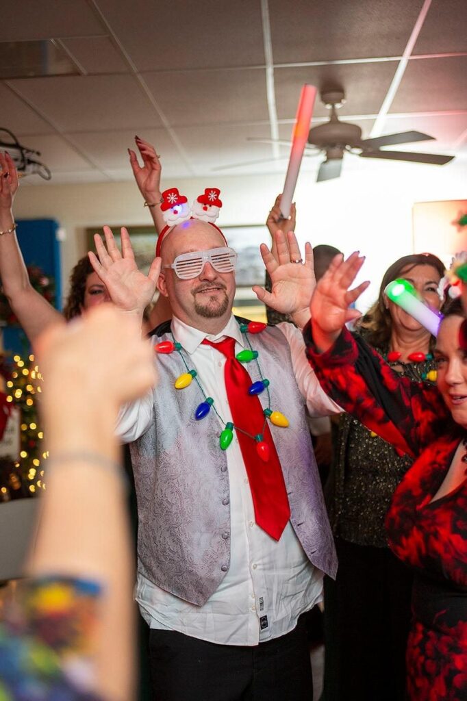 Groom wearing a silly headband dances at winter Pinckney wedding reception