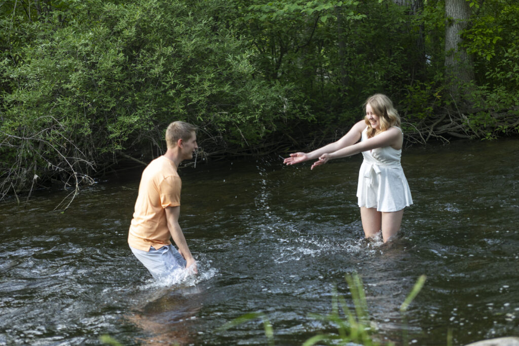 Dakota and Talia splashing each other in the river at Hudson Mills Metropark