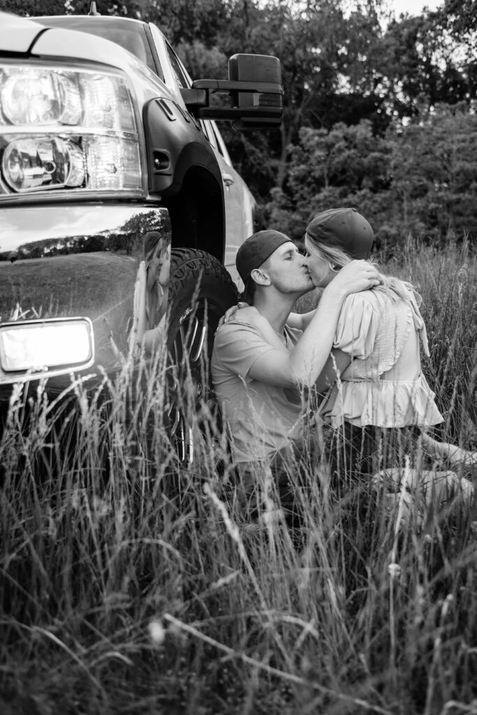 Dakota and Talia leaning against his truck, kissing