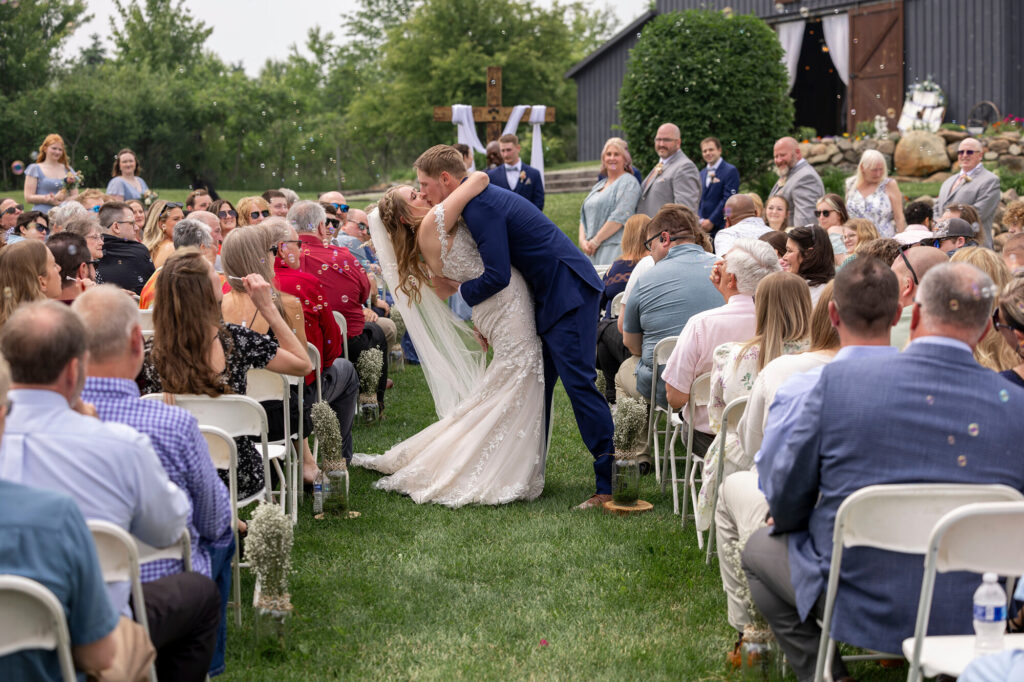 Couple kissing during bubble exit after wedding ceremony