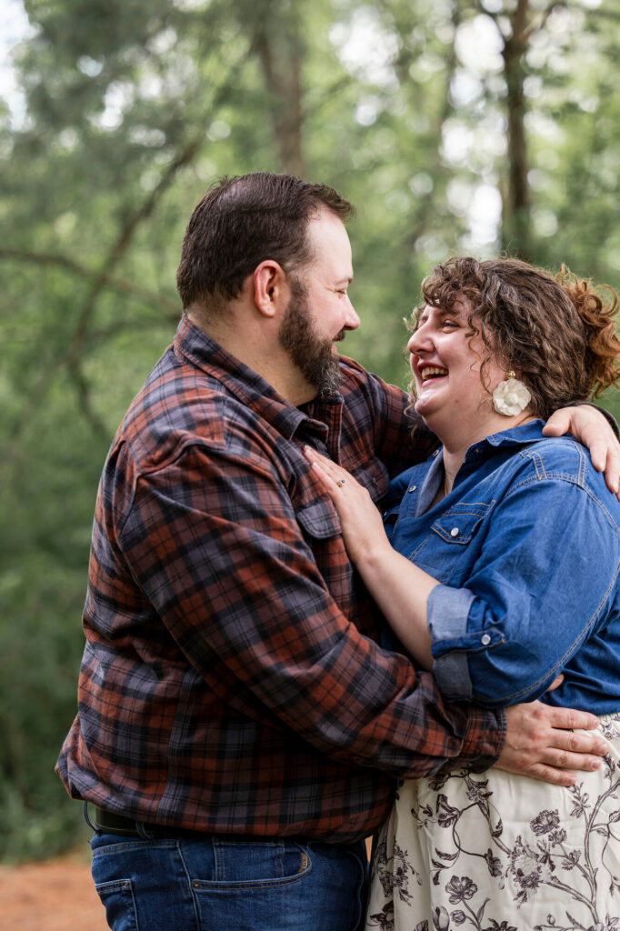 Close-up of Natalie and Collin laughing together on a tree-lined path